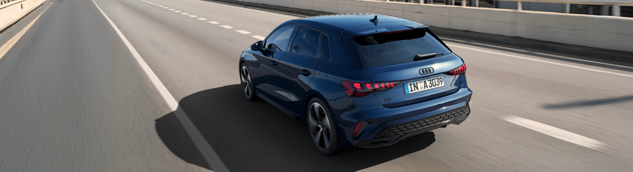 Blauer Audi A3 von schräg hinten fährt auf einer A