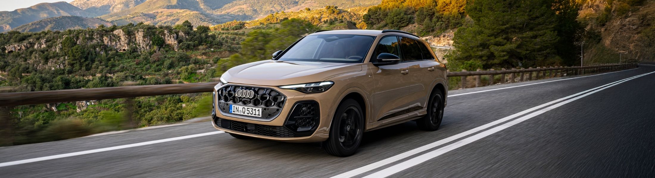 Beiger Audi Q5 fährt auf einer Landstraße