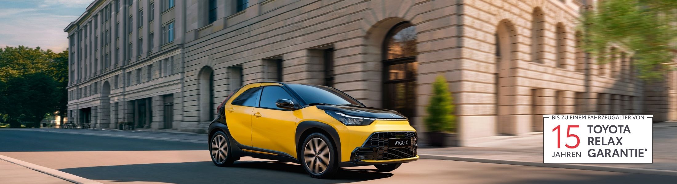 gelb-schwarzer Toyota Aygo fährt auf einer Stadtst