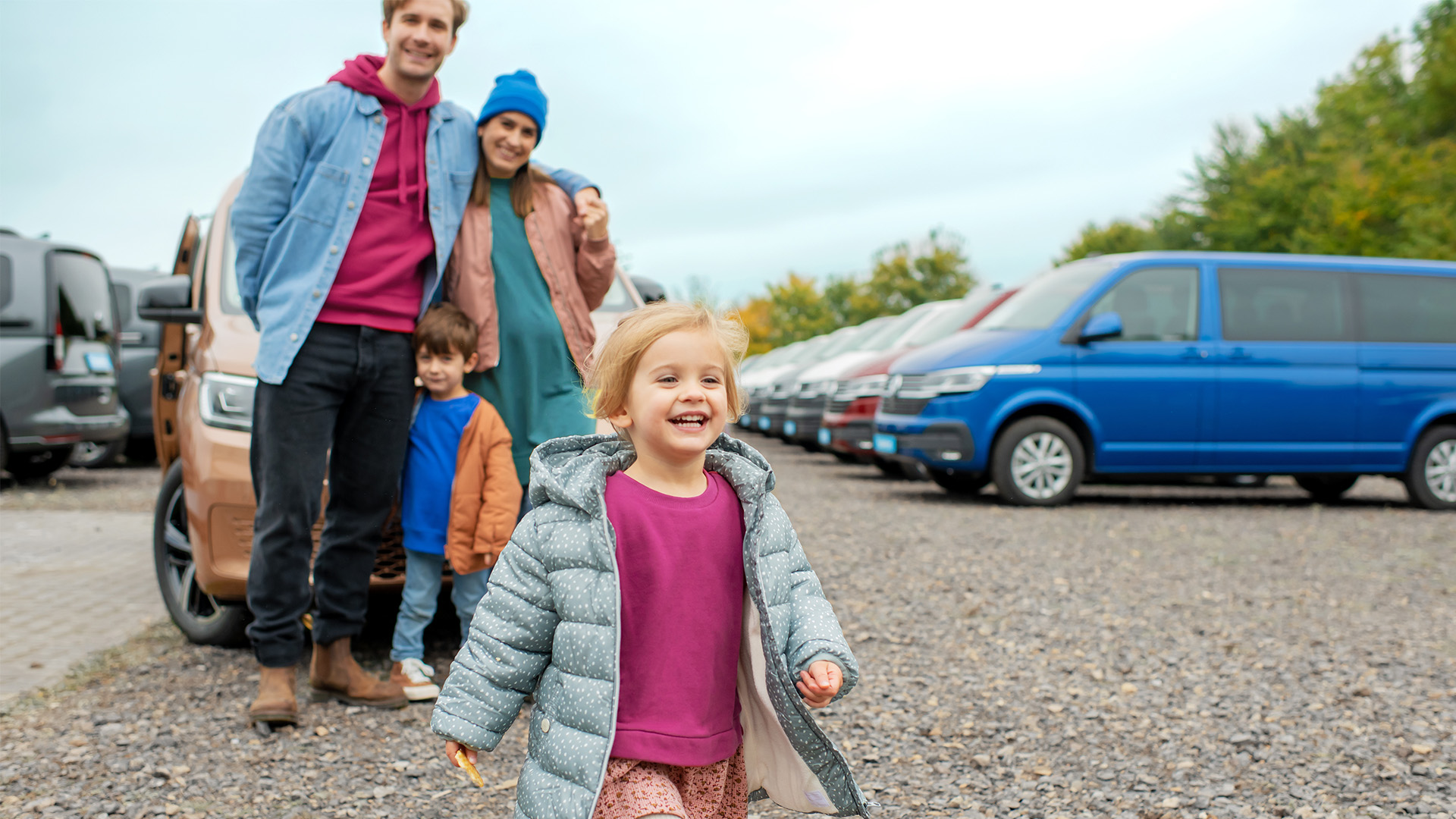 Eine Familie vor mehreren VW Multivans