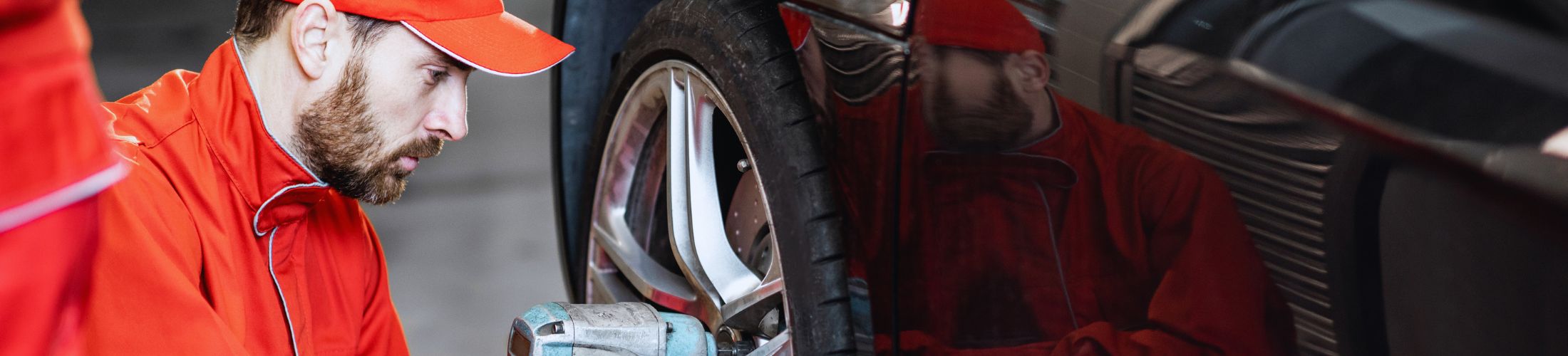 Mechaniker in roter Arbeitskleidung und roter Kapp